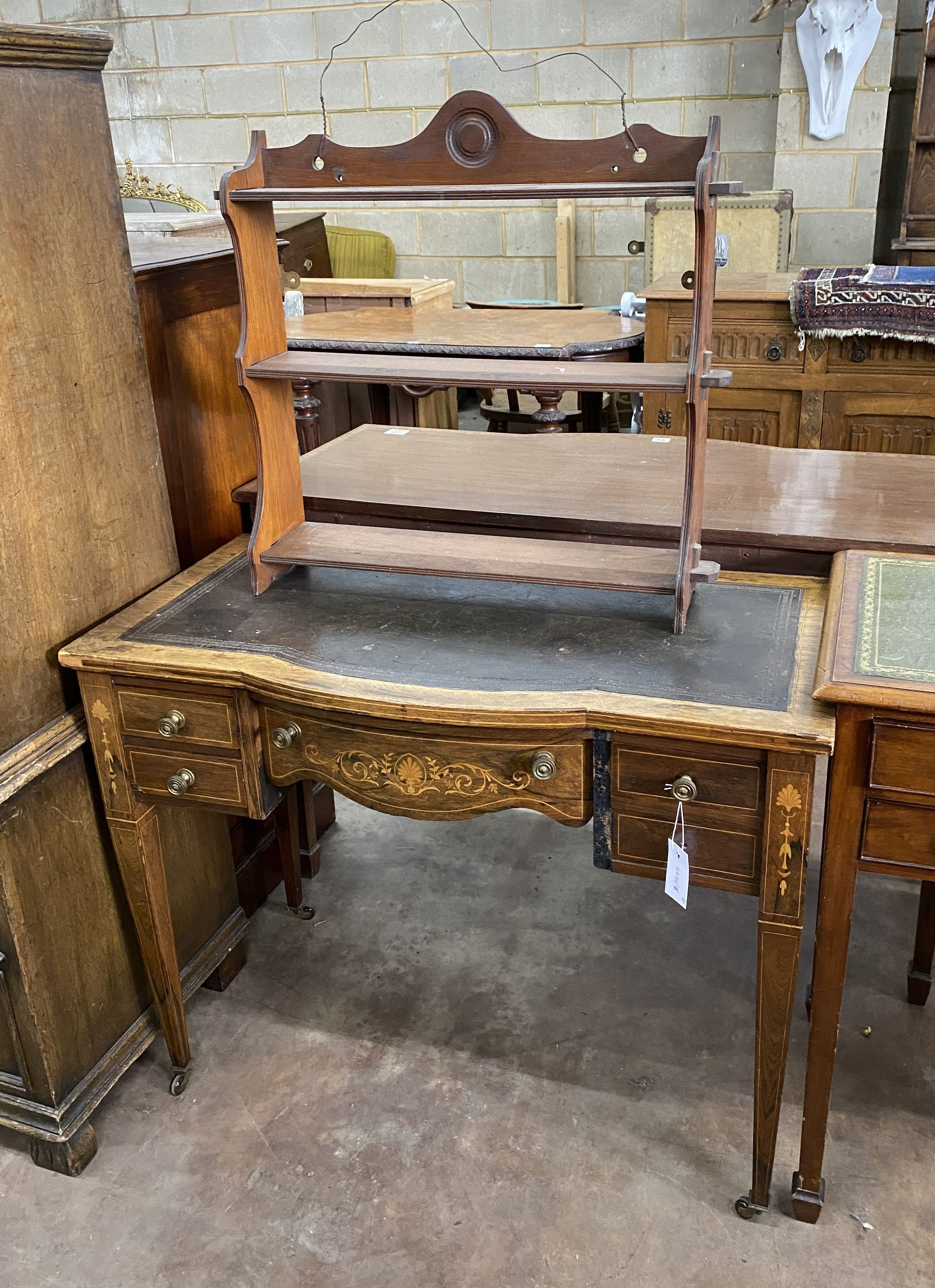 An Edwardian rosewood and marquetry inlaid bow front writing table, width 91cm, depth 49cm, height 72cm and a Victorian walnut three tier wall bracket